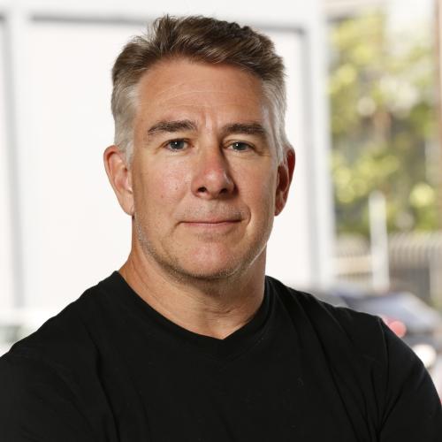 headshot of man wearing a black shirt