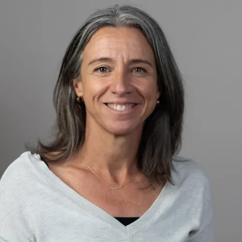 headshot of woman in a white shirt against a gray background