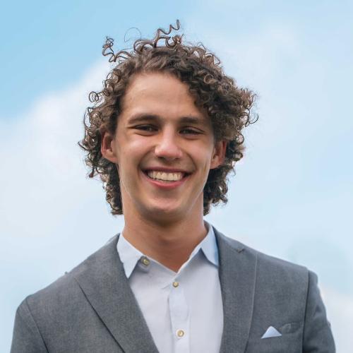 headshot of man against a blue sky background